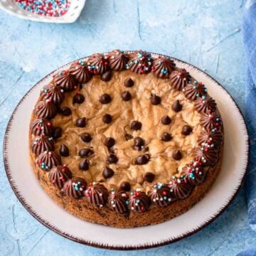 Mini chocolate chip cookie cake decorated with chocolate whipped cream.
