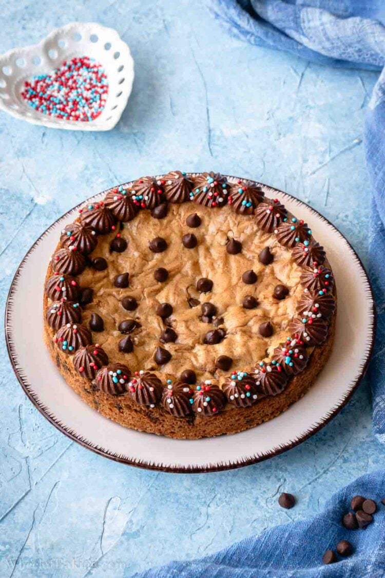 Mini chocolate chip cookie cake decorated with chocolate whipped cream.
